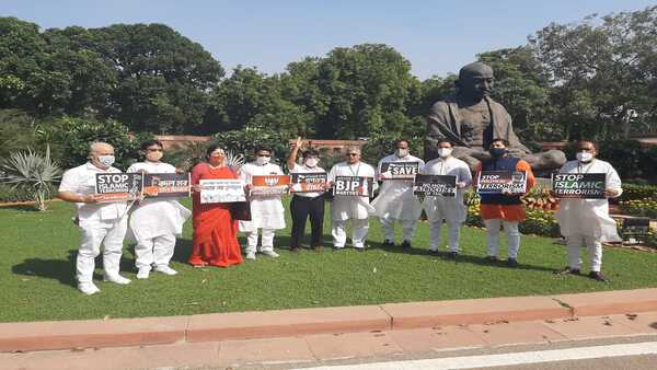  সংসদের বাইরে প্ল্যাকার্ড নিয়ে বিক্ষোভ