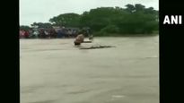 Watch: Man gets swept away while trying to cross overflowing bridge