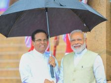 கொட்டும் மழைக்கு மத்தியில் கொழும்பு சென்ற மோடி.. குடை பிடித்த சிறிசேனா! 