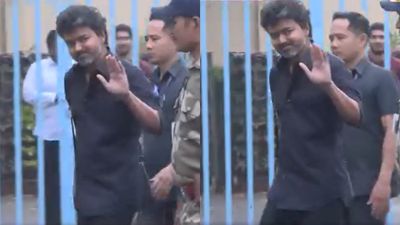 சிரித்தபடியே கை ஆட்டிய விஜய்.. அதென்ன கையில் 