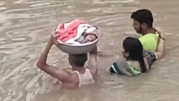 ঠিক যেন বাহুবলী! বুক সমান জলে বাবার মাথায় চেপেই চলল একরত্তি, ভাইরাল ভিডিওতে কমেন্টের বন্যা