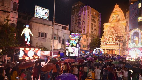আচমকা বর্ষণ চতুর্থীর সন্ধ্যায়, উৎসবমুখর কলকাতায় ছাতা মাথায় ঠাকুর দেখা