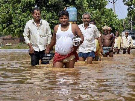 પૂરમાંથી પસાર થતા માણસો