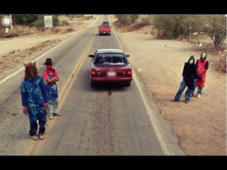 People in Strange Masks in the Desert
