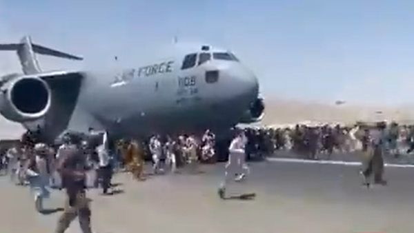 કેટલાક લોકો વિમાનના પૈડા પર બેઠા કેટલાક લોકો વિમાનના પૈડા પર બેઠા