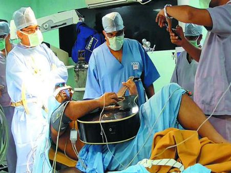 ब्रेन सर्जरी के ऑपरेशन के दौरान गिटार बजाता रहा यह शख्स, VIDEO सोशल पर वायरल
