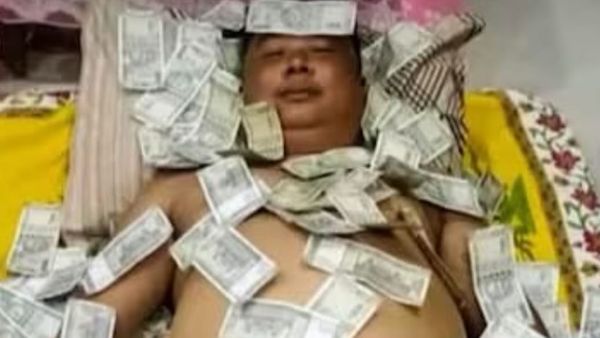 Fact Check: नोटों की गड्डी पर सो रहे बेंजामिन बासुमतारी की फोटो का क्या है सच? जानिए