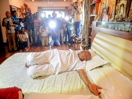 In a room full of photographers, Deve Gowda strikes yogic postures on bed