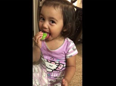 Little girl chuckles after licking on something she finds exciting