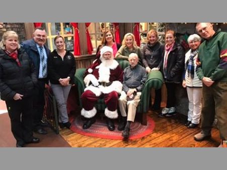 Santa Claus goes down on knees in busy shopping mall to salute a World War II veteran