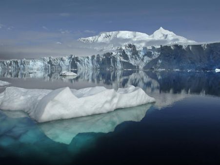 Why are some Antarctic icebergs emerald green in colour?
