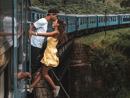 Portuguese traveller couple takes romantic photo hanging outside train