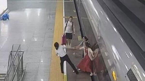 Woman tries to stop high-speed train by sticking her foot in the platform gap