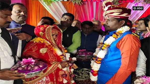 Extraordinary wedding, bride and groom exchange onion garlands