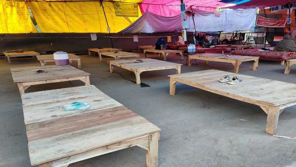 No women, just slippers on wooden beds at Shaheen Bagh