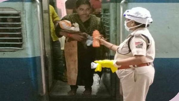 Motherly touch by police woman calms baby on train