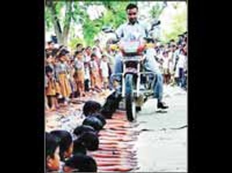 மாணவர்கள் கை மீது பைக்கை ஓட்டி சாகஸம்-சர்ச்சை