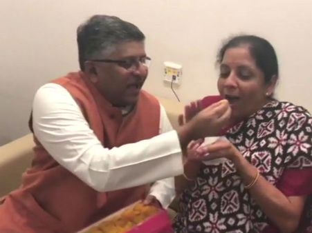 நிர்மலா சீதாராமனுக்கு இனிப்பு ஊட்டிவிட்ட மத்திய அமைச்சர் ரவிசங்கர் பிரசாத்