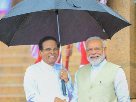 கொட்டும் மழைக்கு மத்தியில் கொழும்பு சென்ற மோடி.. குடை பிடித்த சிறிசேனா!