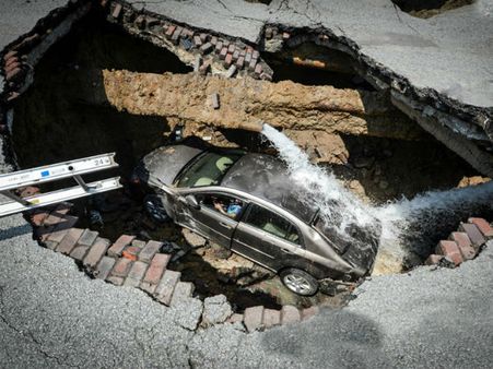 నడి రోడ్డుపై భారీ గుంత: కారుతో సహా పడిన మహిళ