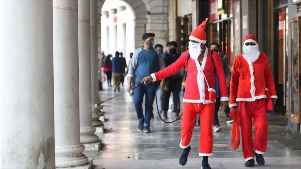 સાંતા ક્લૉઝનો પરિવેશ ધારણ કરીને કનૉટ પ્લેસને સૅનેટાઇઝ કરી રહેલા યુવાન