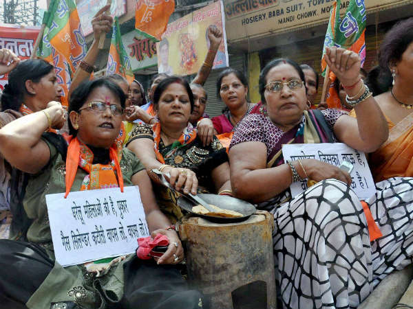 घरेलू सामानों के साथ सड़क पर महिलाओं का विरोध प्रदर्शन