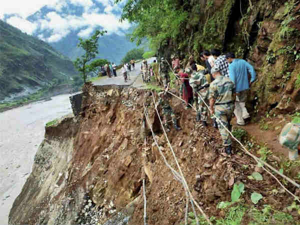 प्रियजनों की तस्वीरें हाथों में लिए लोग 