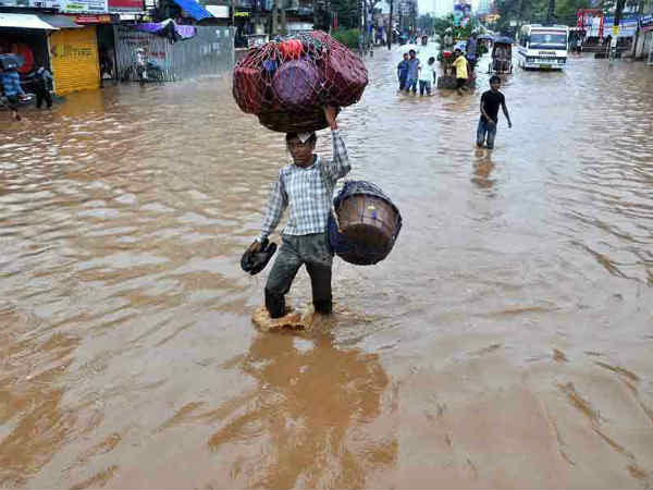 असम में बाढ़ ने हजारों लोगों को विस्‍थापित किया।