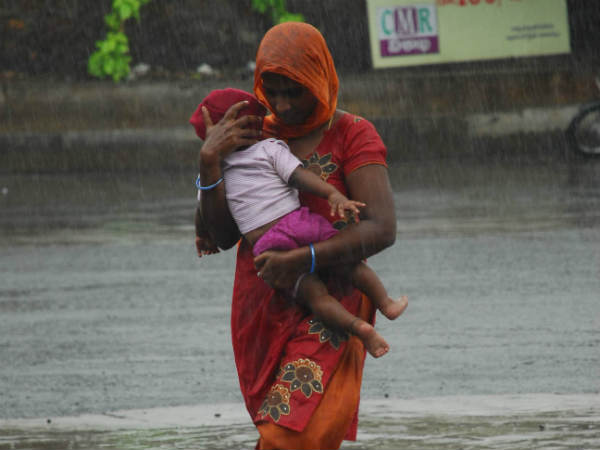 Mother saving kid during hudhud | एक मां अपने बच्चे को ले जाती हुई 