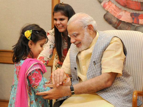 बच्‍चों से राखी बंधवाते पीएम मोदी 