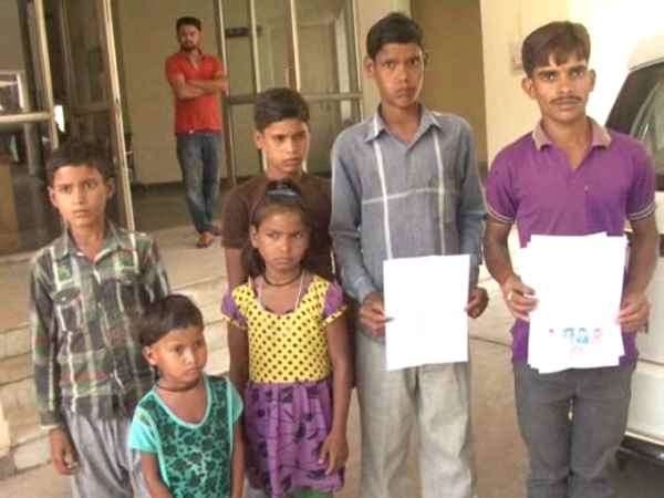 पुलिस के पैर छू मां से मिलाने की गुहार कर रहे बच्चे