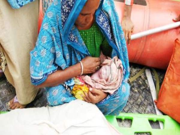 Woman trapped in a gruesome flood give birth to child in a boat