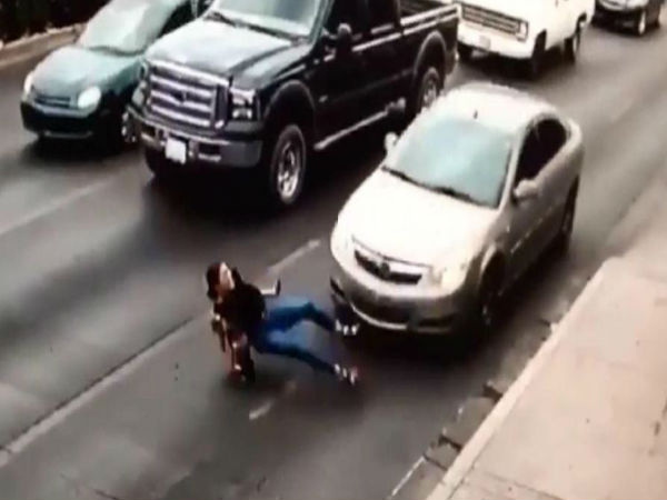  Shocking moment a woman running across a busy road in high heels with her phone in her hand slips and is hit by a car