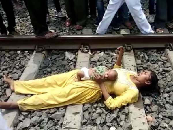 आंखें बंद कर बच्ची के साथ पटरी पर