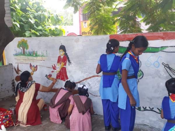school kids draw messagefull paintings on the goverment wall in up
