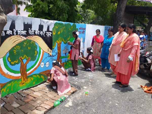 school kids draw messagefull paintings on the goverment wall in up