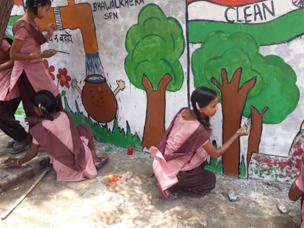 school kids draw messagefull paintings on the goverment wall in up