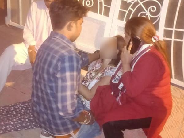 घर के बाहर धरने पर बैठी महिला