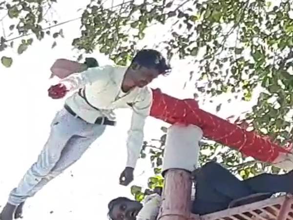 Devotees hanging on 25 feet long pillar of temple at ratlam 