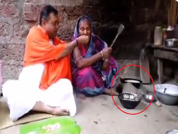 बुजुर्ग महिला चूल्हे पर खाना पका रही है