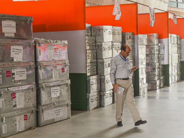 सुपरवाइजर काउंटिंग एजेंट्स EVM के सील की जांच करते हैं 