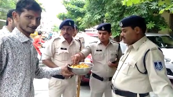 पुलिसकर्मी को खिलाई गई मिठाई