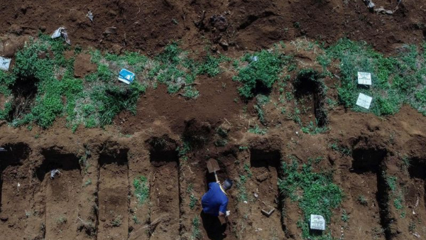 पुरानी कब्र को खोद कर निकाली जा रही हड्डियां 