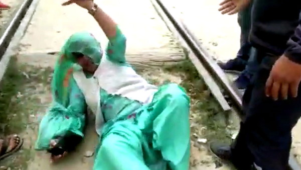 ट्रेन गुजरने के बाद ट्रैक से उठी महिला