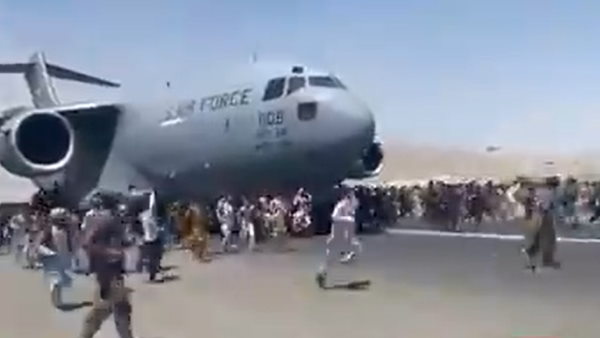  विमान के पहिए पर कुछ लोग बैठे