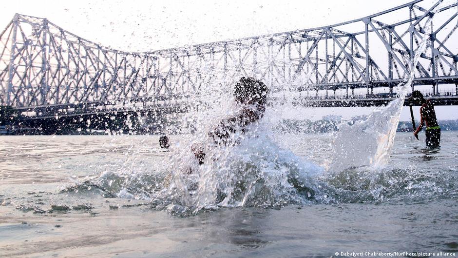 कोलकाता में गर्मी से बचने के लिए हावड़ा पुल के पास गंगा नदी में गोता लगाते बच्चे कोलकाता में गर्मी से बचने के लिए हावड़ा पुल के पास गंगा नदी में गोता लगाते बच्चे