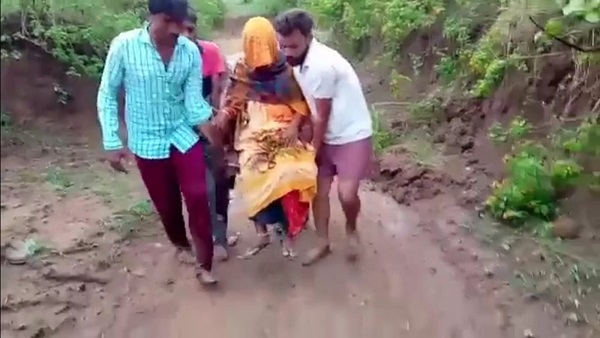 प्रसूता के दलदली और कीचड भरी सडक से ले जाते युवक 