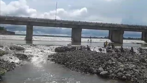 बांध के स्‍प‍िल-वे में इस तरह चट्टाटानोंं के बीच जा रहे लोग 