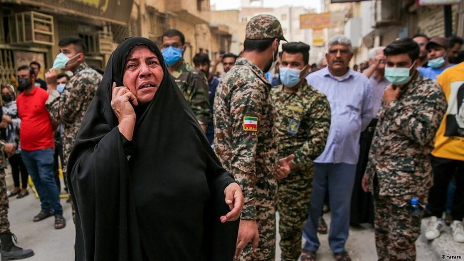 मेट्रोपोल के मलबे के नीचे से अपने परिवार के सदस्यों को बचाए जाने के लिए परेशान एक महिला