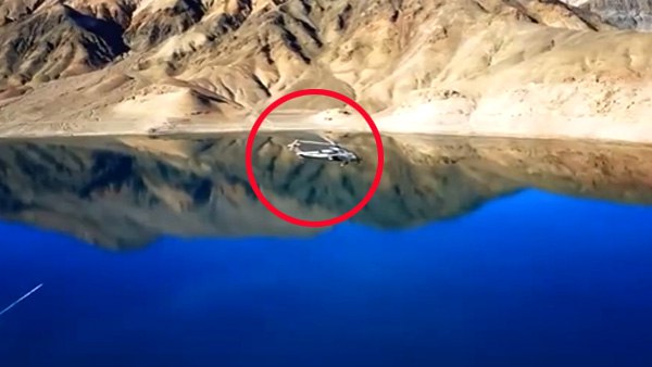 झील के ऊपर से उड़ान भर रहे हेलीकॉप्टर
